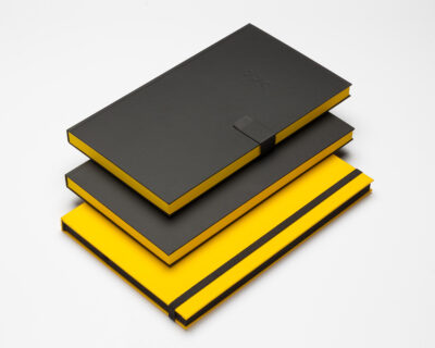 Stack of black and yellow notebooks with a minimalist design