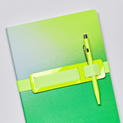 Neon-grünes Notizbuch mit Textur und passendem Stift befestigt mit einer breiten gelben Gummibandhalterung