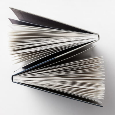 Geöffnetes Notizbuch von oben betrachtet mit sichtbaren weißen Seiten und dunklem Einband
