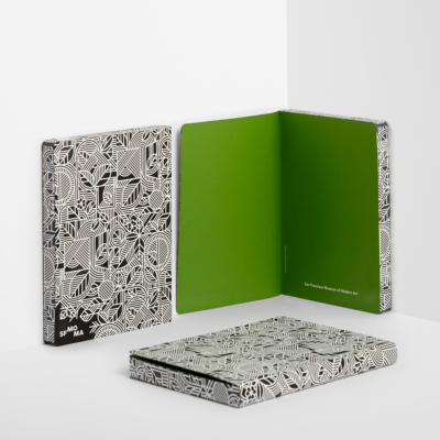 Schwarz-weiße Notizbücher mit geometrischem Muster und leuchtend grünen Innenseiten