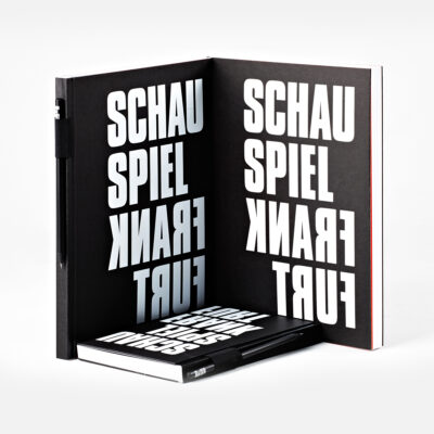 Black and white book with vertically printed words 'SCHAU', 'SPIEL', 'FRANK', and 'FURT'